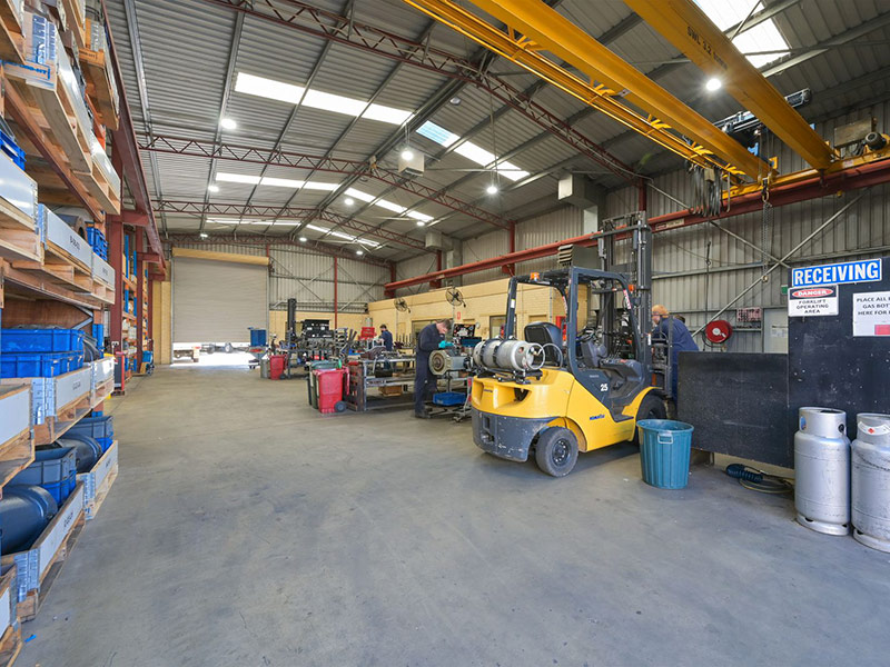 Inside view of a factory with shelves of storage and forklift